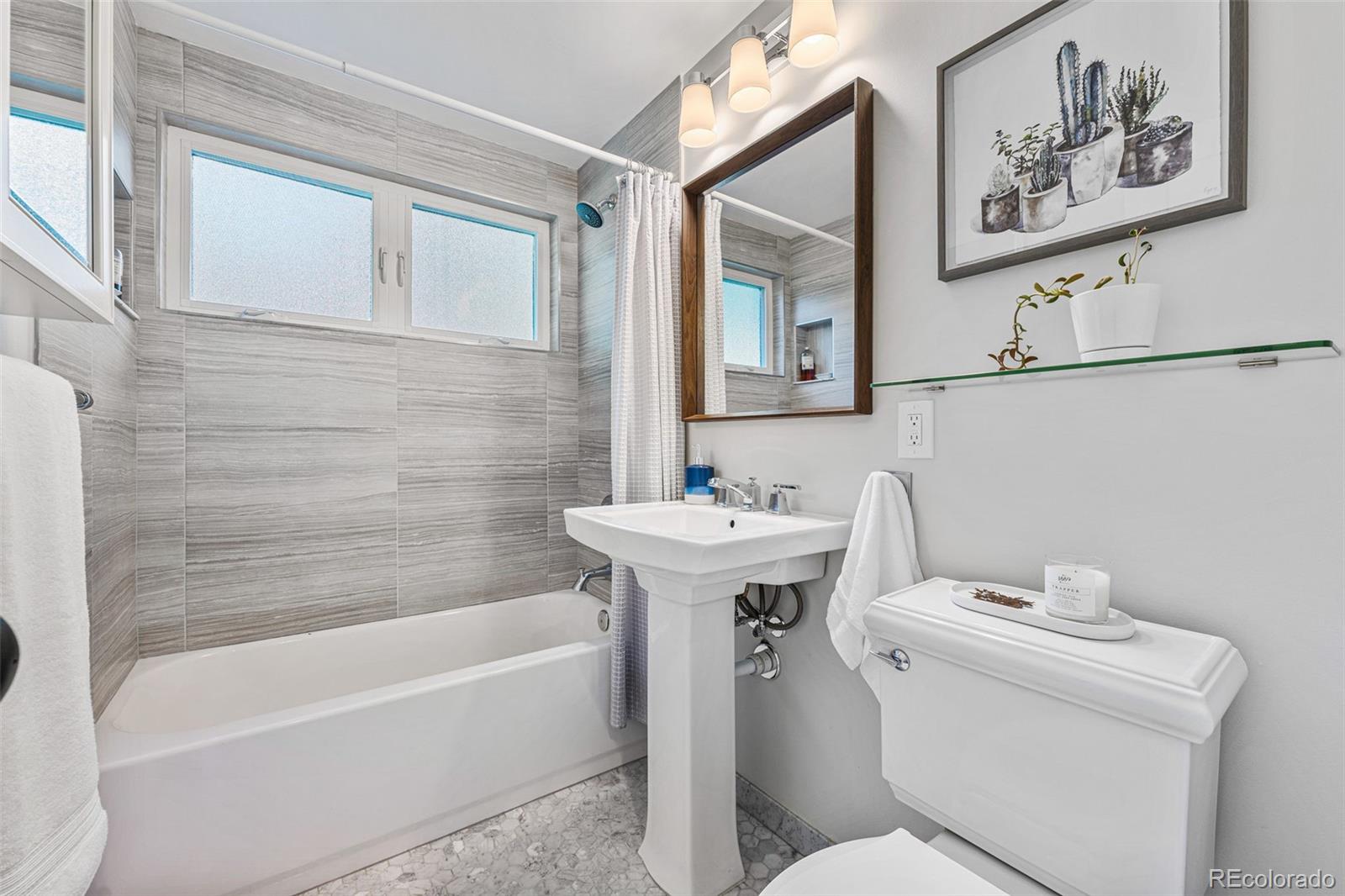 3885 Cody Street Wheat Ridge, CO 80033 - Photo 25 of 40 a bathroom with a sink and mirror with toilet