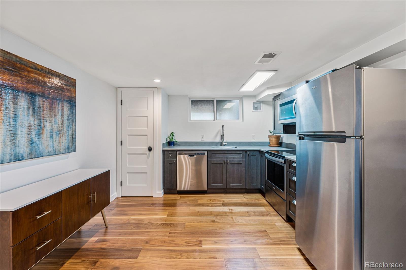 3885 Cody Street Wheat Ridge, CO 80033 - Photo 28 of 40 a kitchen with granite countertop a refrigerator and a sink