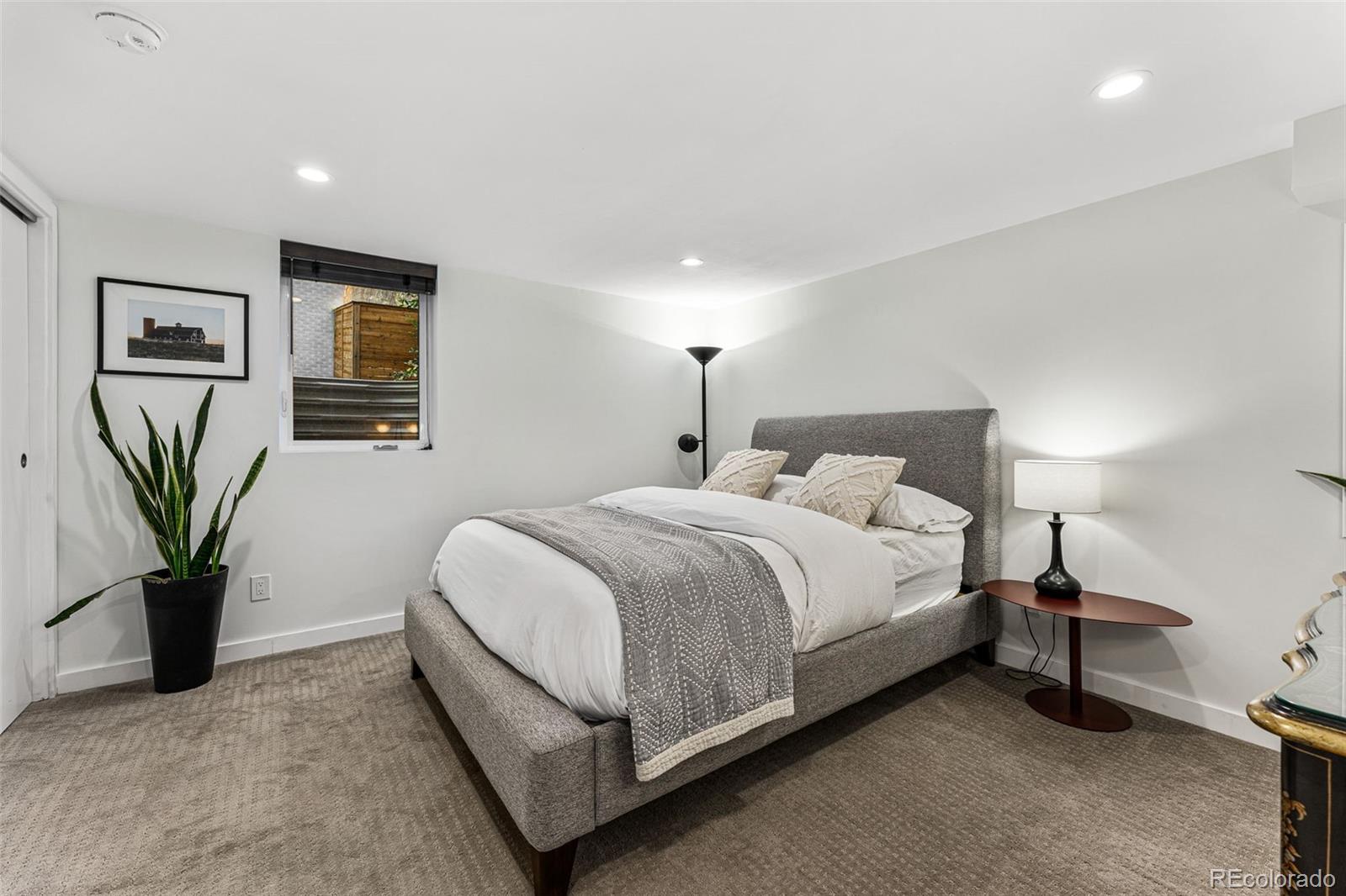 3885 Cody Street Wheat Ridge, CO 80033 - Photo 30 of 40 a bedroom with a bed and a lamp