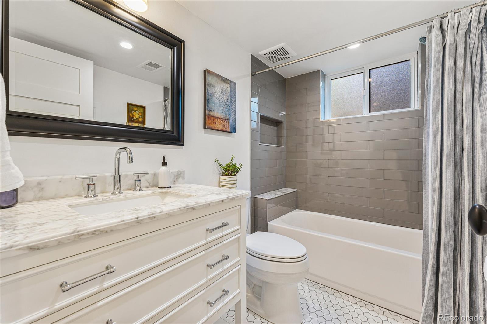 3885 Cody Street Wheat Ridge, CO 80033 - Photo 32 of 40 a bathroom with a granite countertop toilet sink and mirror