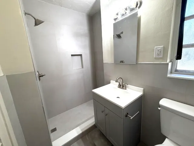 a bathroom with a sink a toilet and mirror
