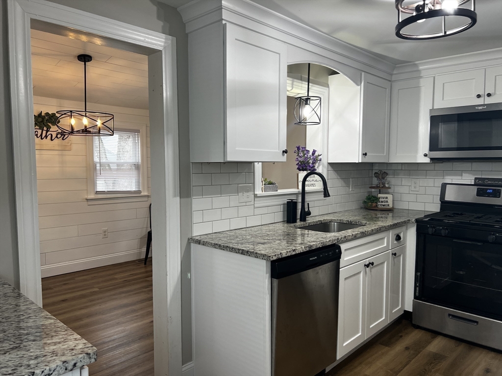 133 Winton Street Springfield, MA 01118 - Photo 6 of 17 a kitchen with a sink granite counter tops and a stove