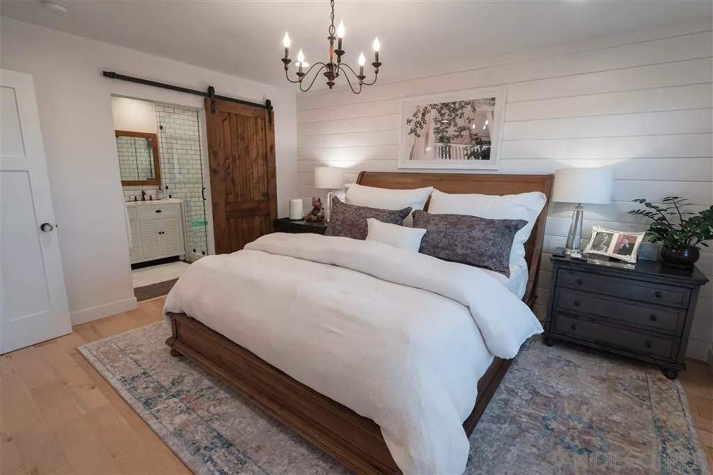 132 Candy Lane Encinitas, CA 92024 - Photo 5 of 24 a spacious bedroom with a bed and a chandelier