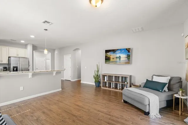 a living room with furniture and a wooden floor