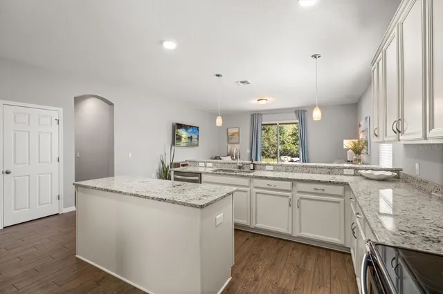 a kitchen with a sink cabinets and wooden floor