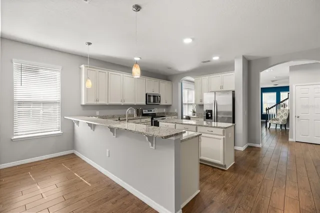 a kitchen with a sink cabinets stainless steel appliances and windows
