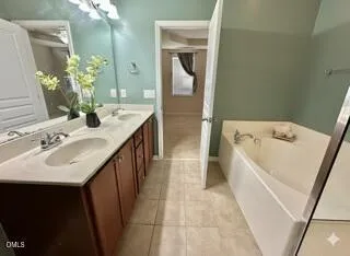 a bathroom with a sink a tub and a mirror