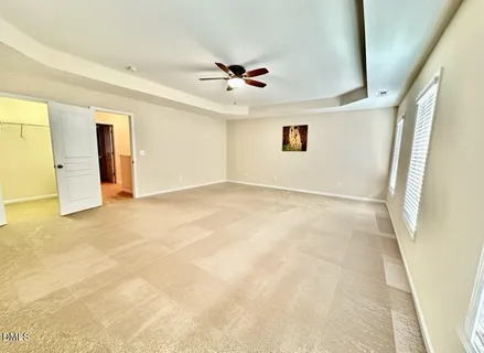 an empty room with ceiling fan and window