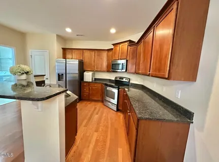 a kitchen with stainless steel appliances granite countertop a sink stove and refrigerator