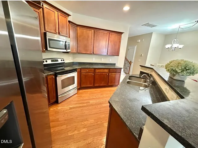 a kitchen with stainless steel appliances granite countertop a sink a stove microwave and refrigerator