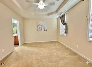 en empty room with windows and chandelier fan