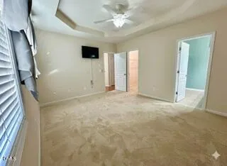 en empty room with windows and ceiling fan