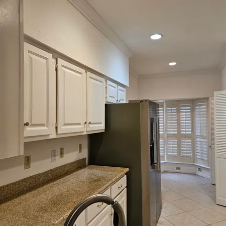 a kitchen with stainless steel appliances granite countertop a refrigerator and a stove top oven
