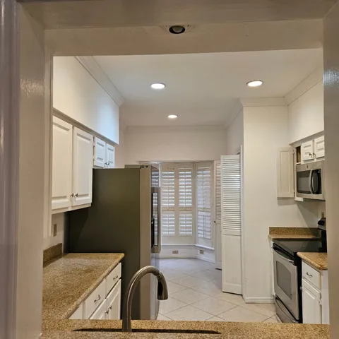 a kitchen with stainless steel appliances granite countertop a refrigerator a sink and a stove