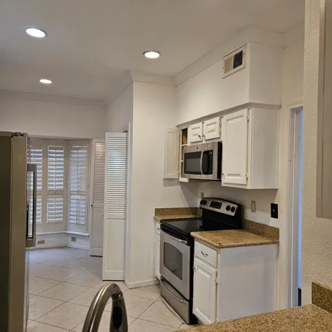 a kitchen with stainless steel appliances granite countertop a stove a sink and a refrigerator