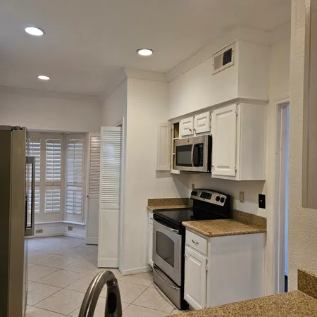 a kitchen with stainless steel appliances granite countertop a stove a sink and a refrigerator