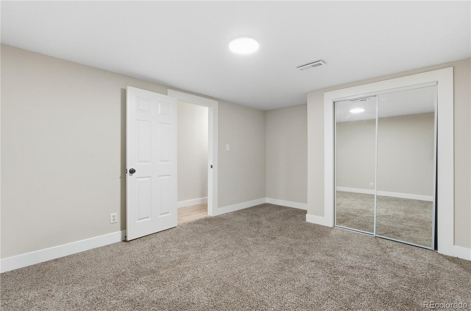 610 6th Street Bennett, CO 80102 - Photo 16 of 34 an empty room with sliding door and chandelier fan