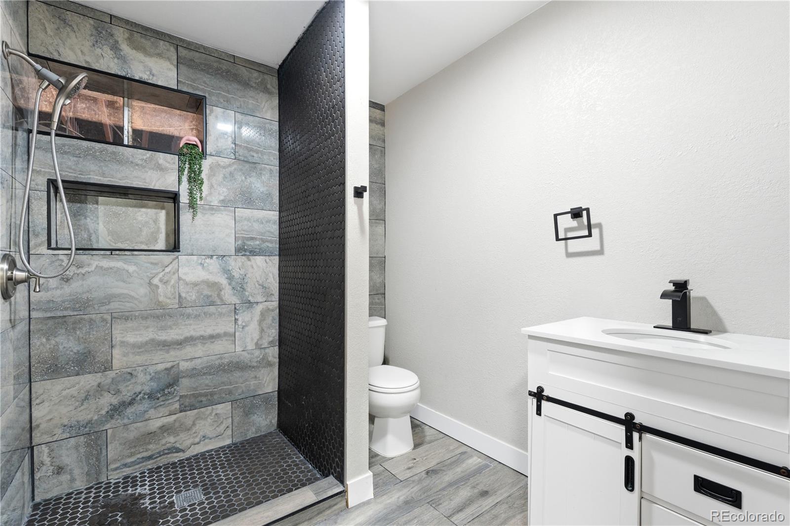 610 6th Street Bennett, CO 80102 - Photo 23 of 34 a bathroom with a sink a toilet and shower