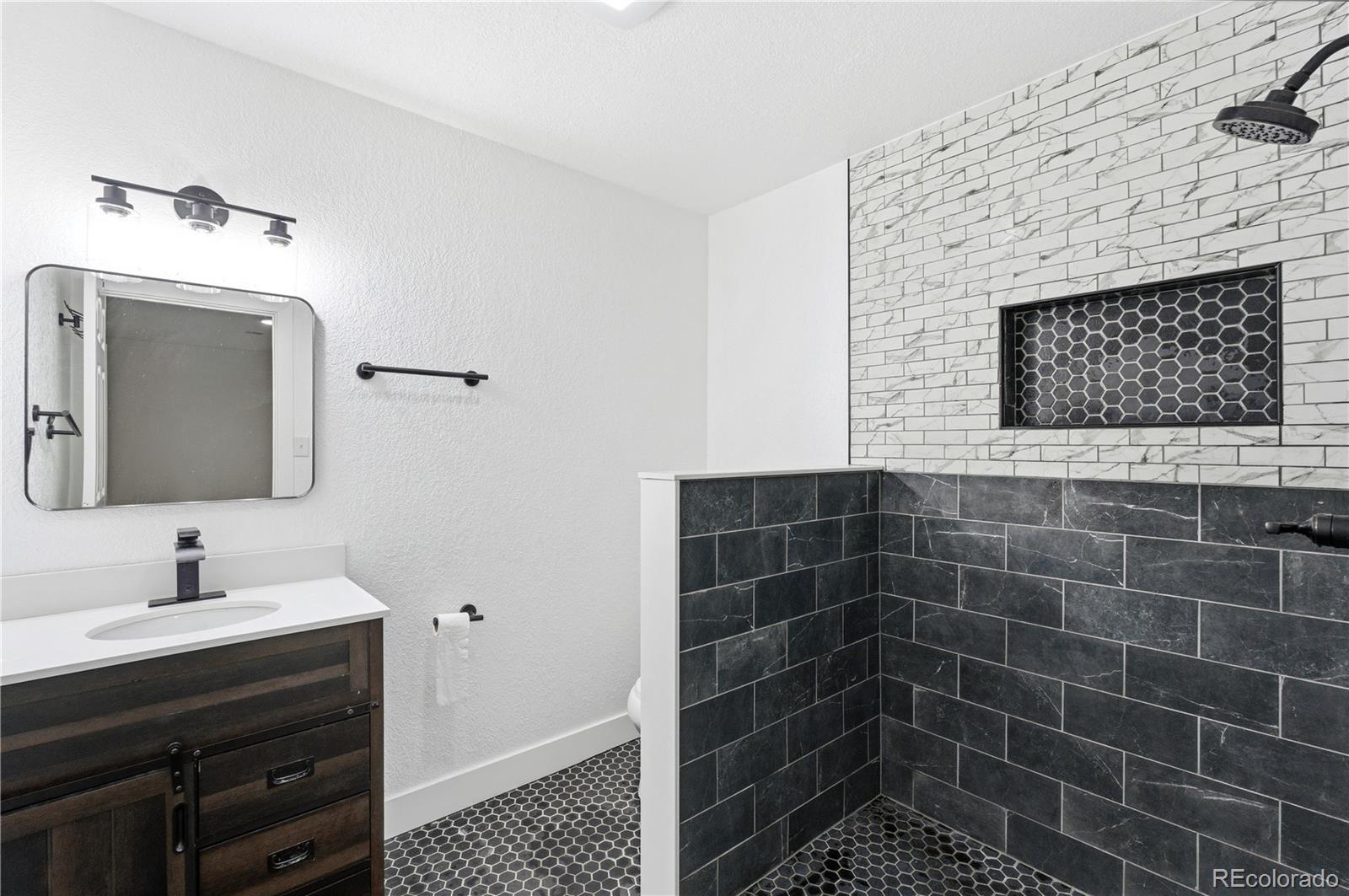 610 6th Street Bennett, CO 80102 - Photo 28 of 34 a bathroom with a sink a toilet and a mirror