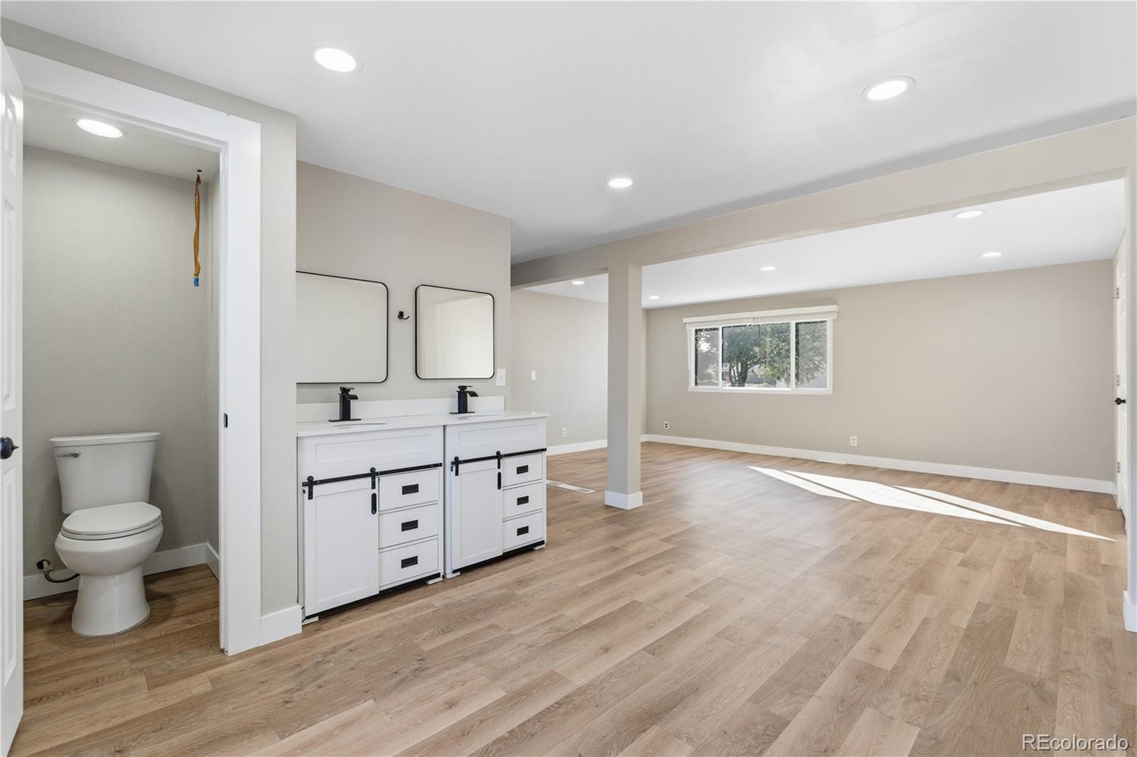 610 6th Street Bennett, CO 80102 - Photo 5 of 34 a bathroom with a sink a toilet and a large mirror