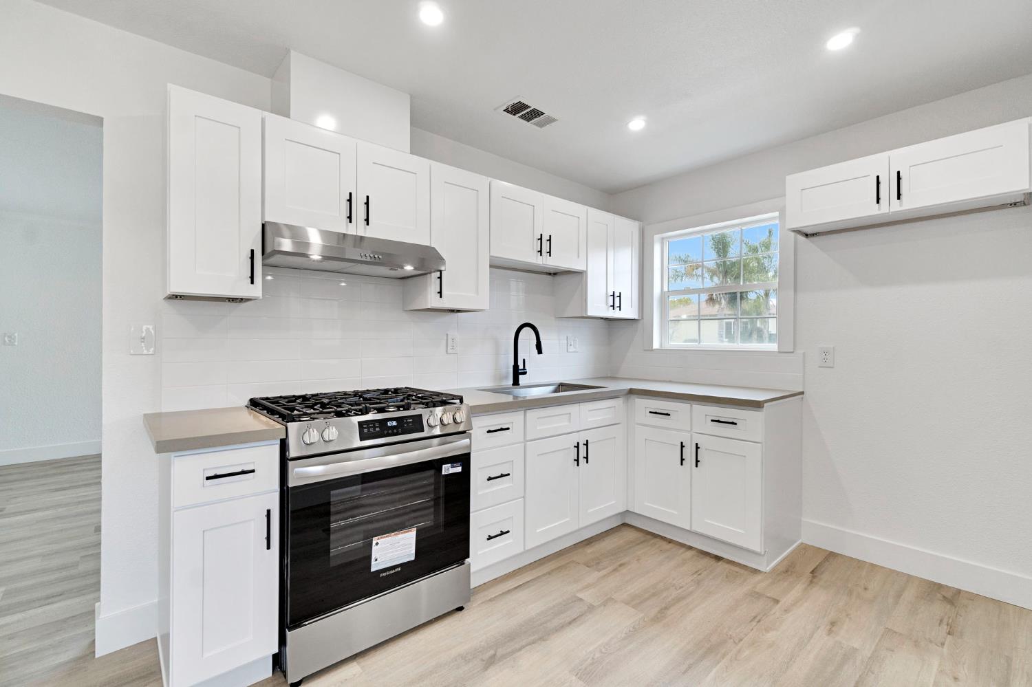 1503 North Pacific Avenue Fresno, CA 93728 - Photo 11 of 26 a kitchen with stainless steel appliances granite countertop a stove a sink and white cabinets