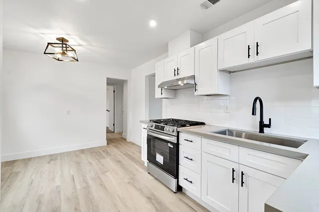 a kitchen with cabinets appliances and a wooden floor