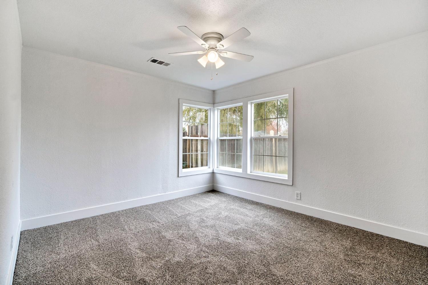 1503 North Pacific Avenue Fresno, CA 93728 - Photo 16 of 26 an empty room with chandelier fan and windows
