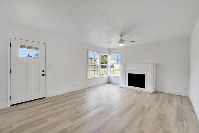 a view of empty room with wooden floor and fireplace