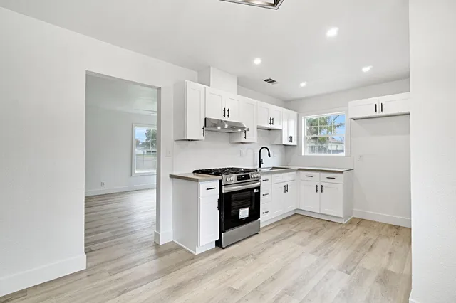 a kitchen with stainless steel appliances granite countertop a stove a sink and a refrigerator
