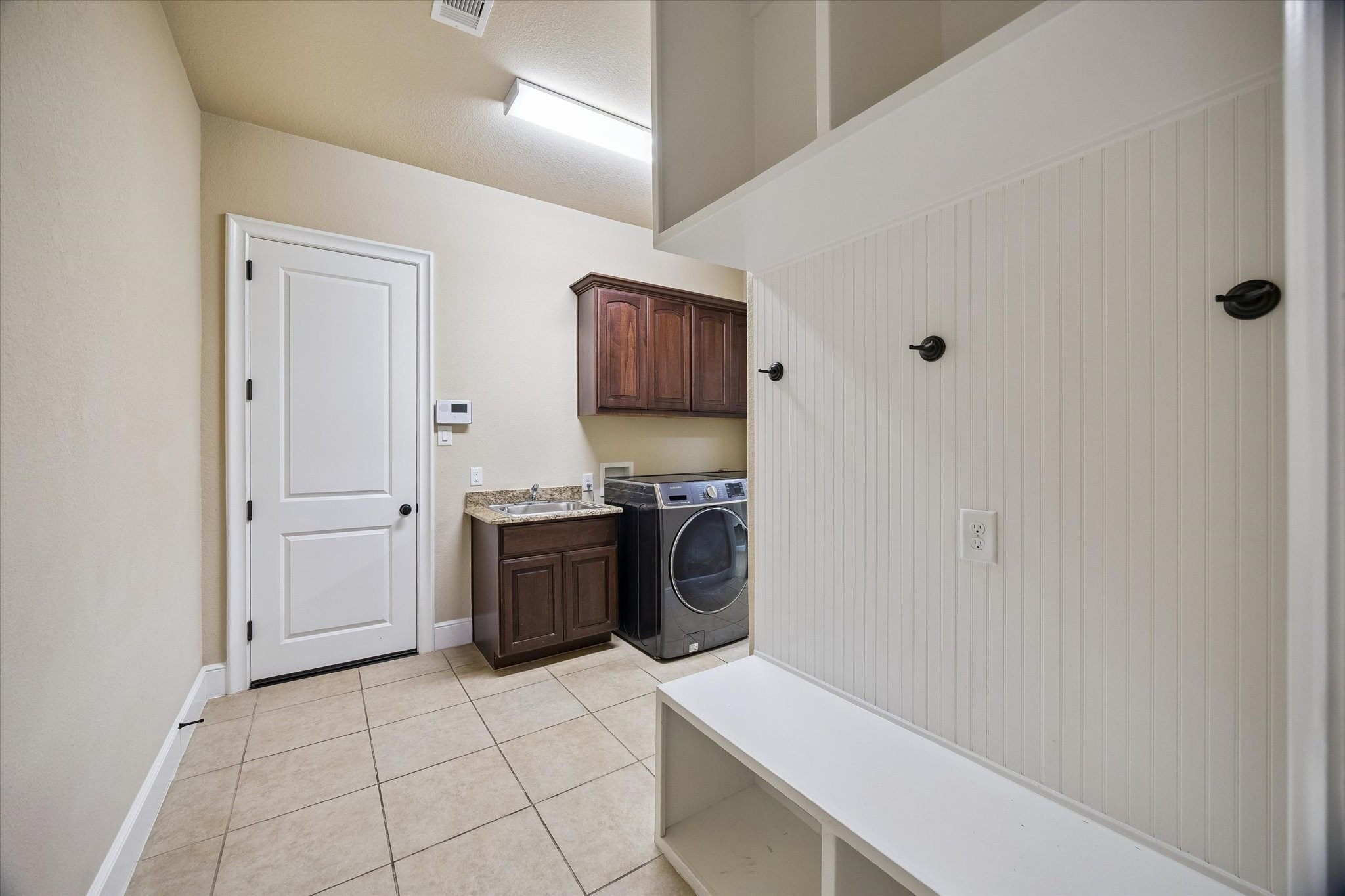 35 North Fremont Ridge Loop Spring, TX 77389 - Photo 16 of 37 Blending functionality with convenience, the well-appointed laundry and mudroom area features a utility sink, built-in cabinetry, bench seating, and storage hooks. Conveniently positioned between the garage and the primary suite, it helps keep daily life organized and efficient.