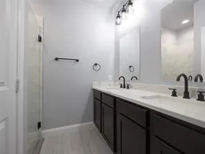 a bathroom with a double vanity sink and a mirror