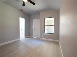 an empty room with windows and fan