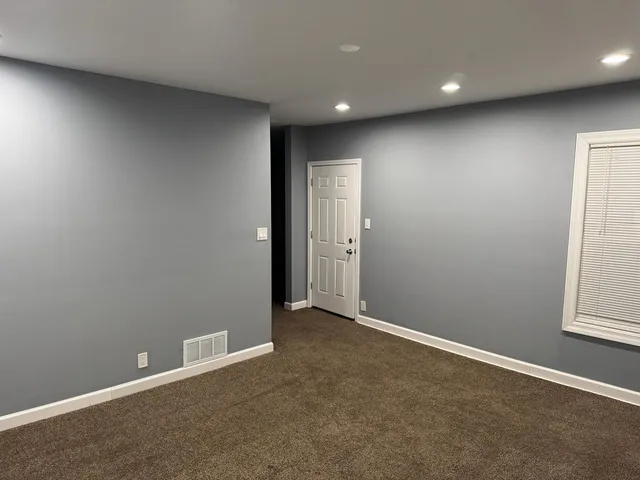 an empty room with windows and closet