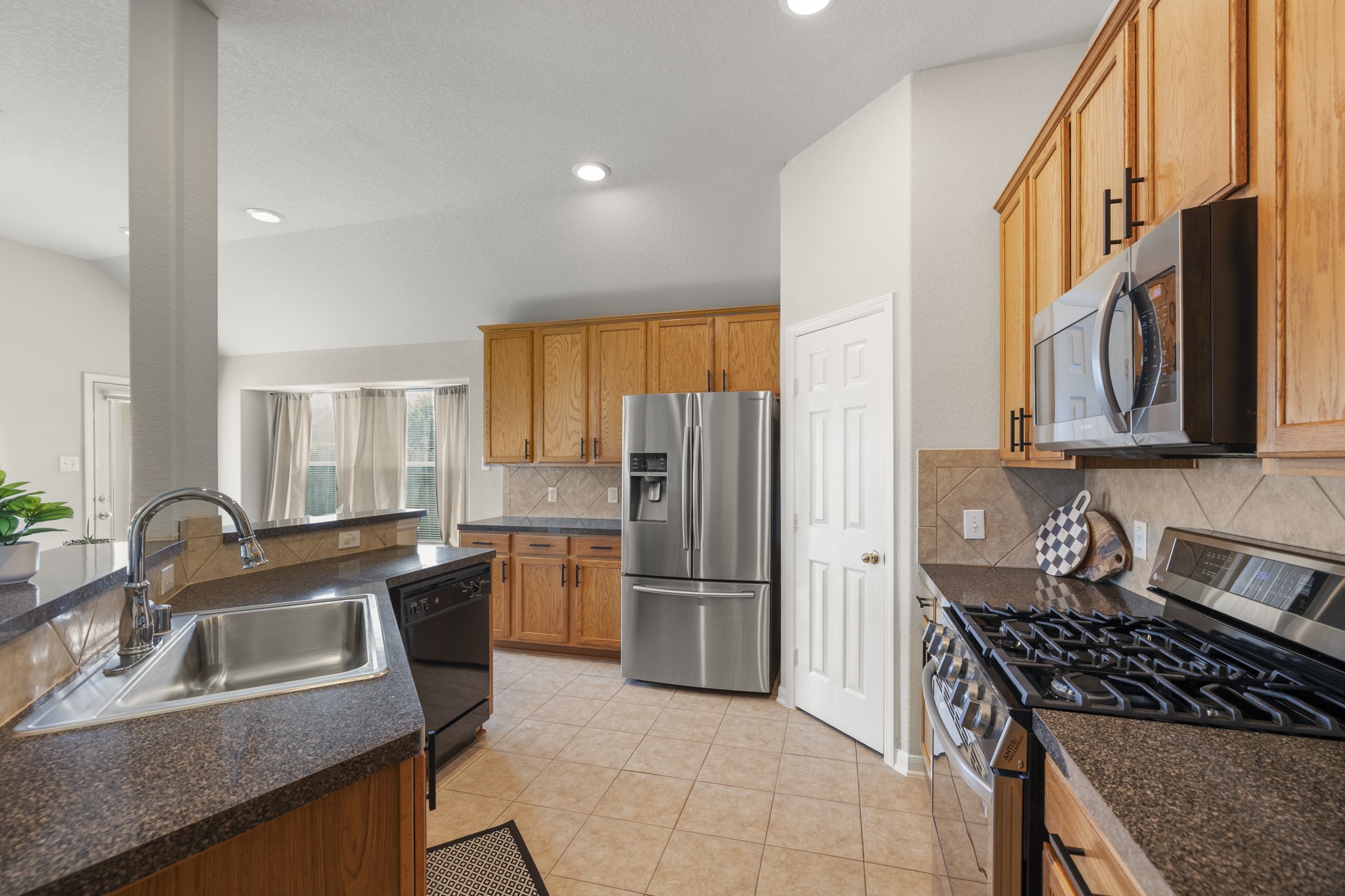3422 Falcon Trail Court Spring, TX 77373 - Photo 11 of 35 a kitchen with granite countertop a sink stove and refrigerator