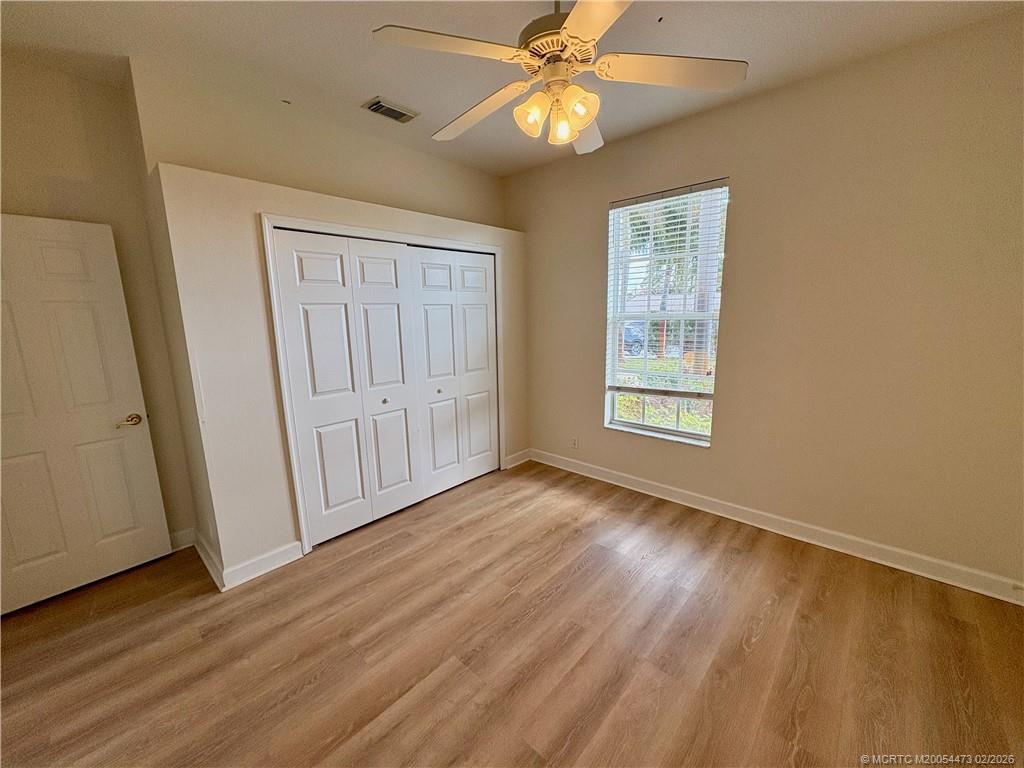 947 Northwest 13th Street Stuart, FL 34994 - Photo 11 of 23 an empty room with wooden floor fan and windows