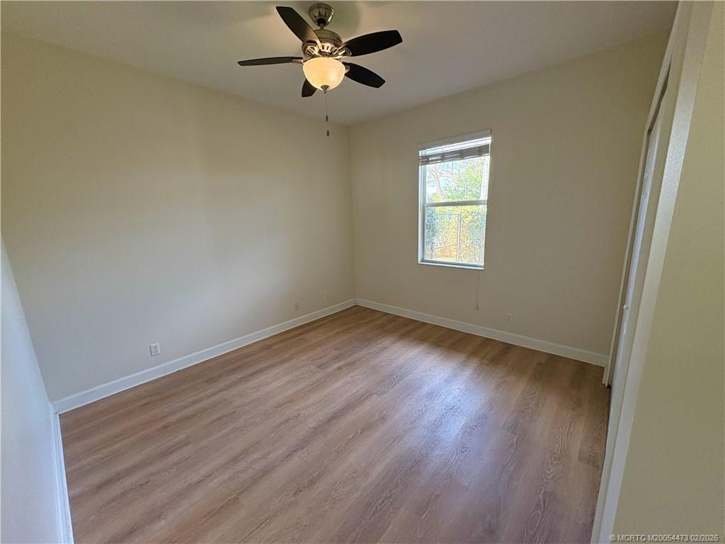 947 Northwest 13th Street Stuart, FL 34994 - Photo 12 of 23 a view of empty room with wooden floor and fan