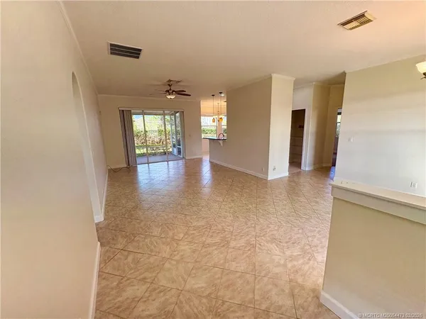 a view of empty room with wooden floor and windows