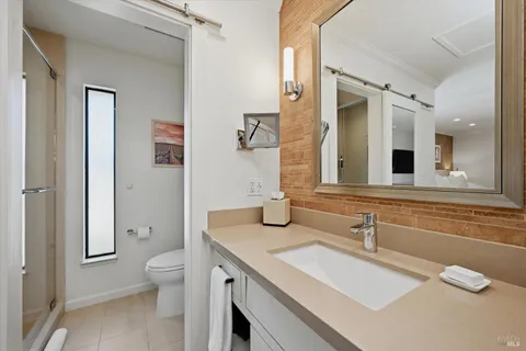 a bathroom with a granite countertop toilet sink and mirror