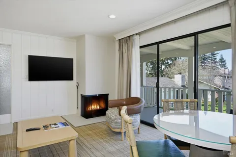 a living room with furniture a flat screen tv and a floor to ceiling window