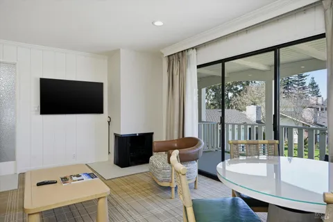 a living room with furniture a flat screen tv and a floor to ceiling window