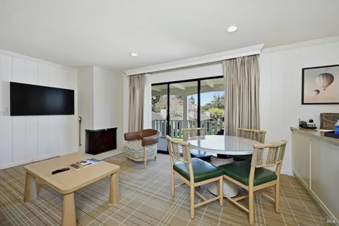 a living room with furniture a flat screen tv and a window