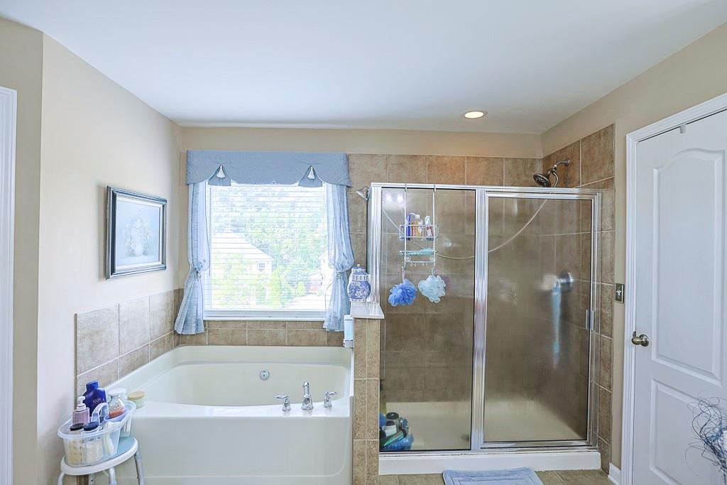 300 Hampton Place Canton, GA 30115 - Photo 63 of 82 a bathroom with a bathtub and a shower