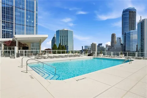 a view of a swimming pool with a lawn chairs and a small yard