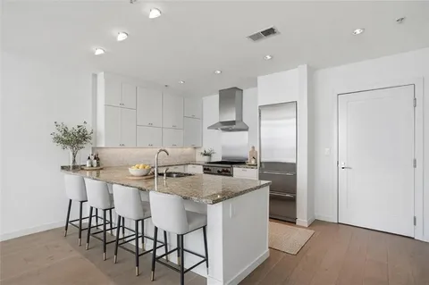 a kitchen with granite countertop a sink and white cabinets