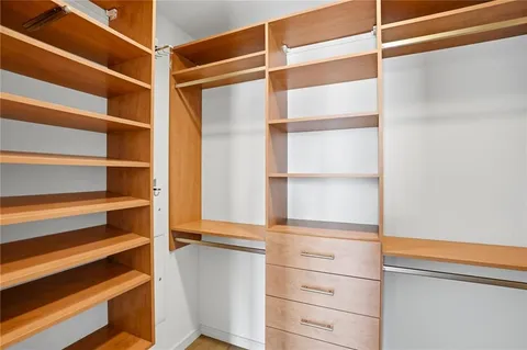 a view of walk in closet with empty racks