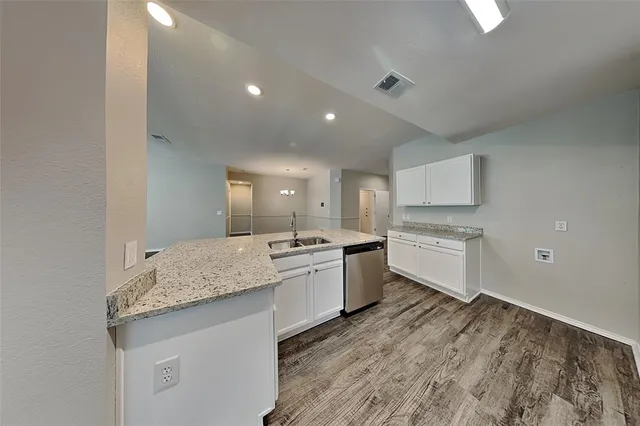 a large kitchen with a sink and dishwasher stove a refrigerator a sink with wooden floor