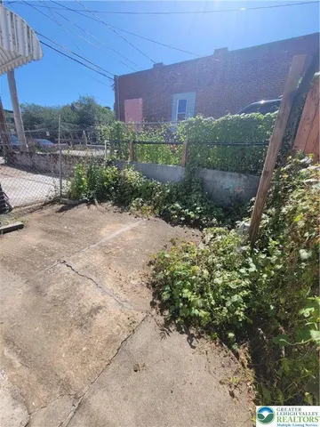 a view of a yard with plants and a building