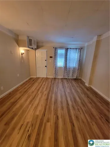 a view of empty room with wooden floor