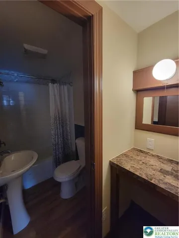 a bathroom with a granite countertop toilet and a sink
