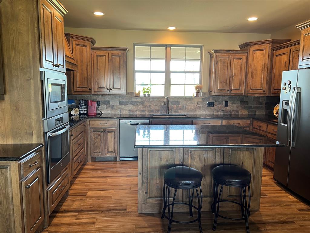 2261 Highway 276 Emory, TX 75440 - Photo 30 of 35 a kitchen with a table chairs refrigerator and microwave